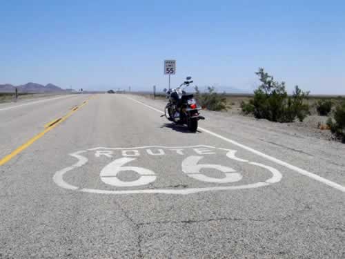 Stopping for a photo op with the motorcycle in the middle of Route 66 Motorcycle rider stopping for a photo op in the middle of Route 66